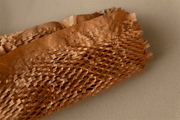 Rolo de papel em formato de favos de mel em 3D que substitui o plástico-bolha como embalagem sustentável para e-commerce. 