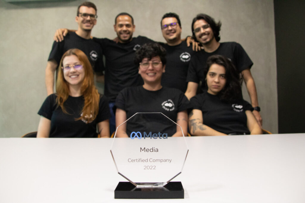 Foto do prêmio de meta media ciertified company recebido pela Nação Digital em 2022 com pessoas desfocadas ao fundo.