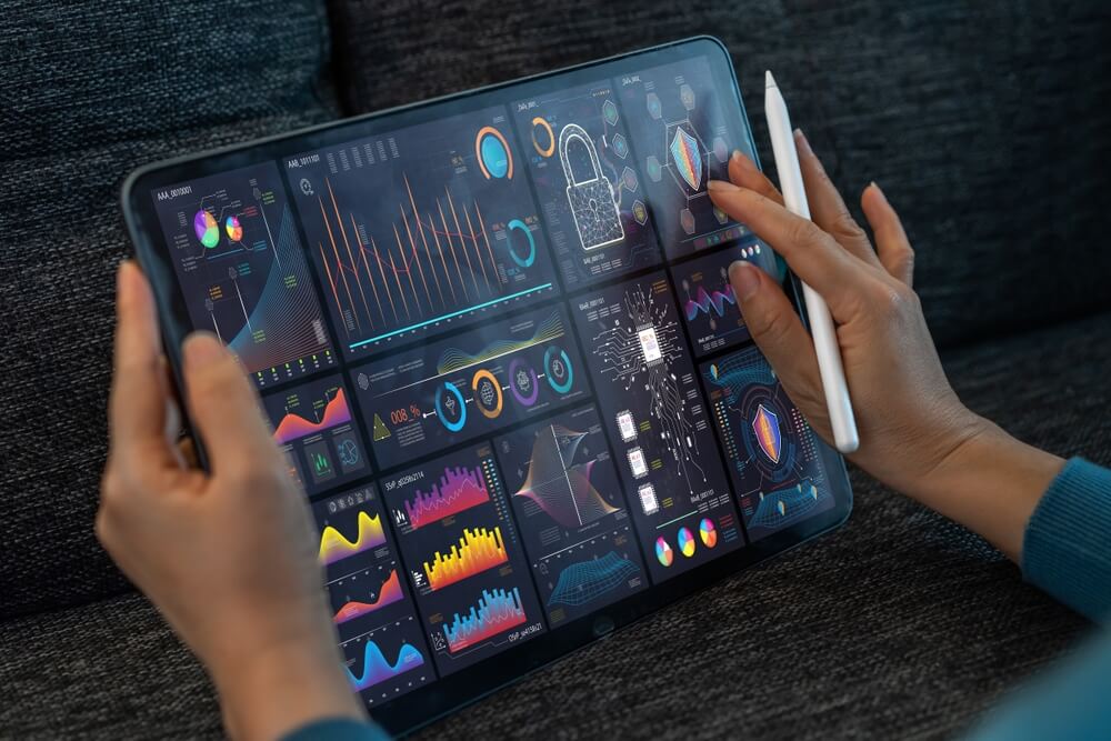 Na imagem é possível ver um tablet. Nele, uma mulher organiza e visualiza dados gerados por plataformas de DMP.
